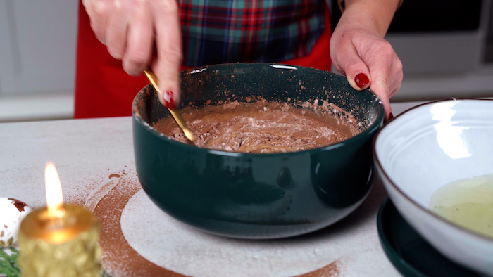 mixture for the cake batter being stirred with a spoon in green ceramic bowl christmas dinner party ideas