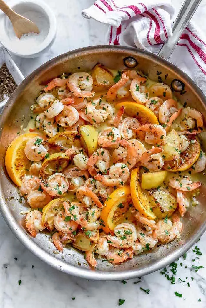 pan seared citrus shrimp garlic shrimp recipe cooked in metal saucepan garnished with chopped parsley lemon wedges