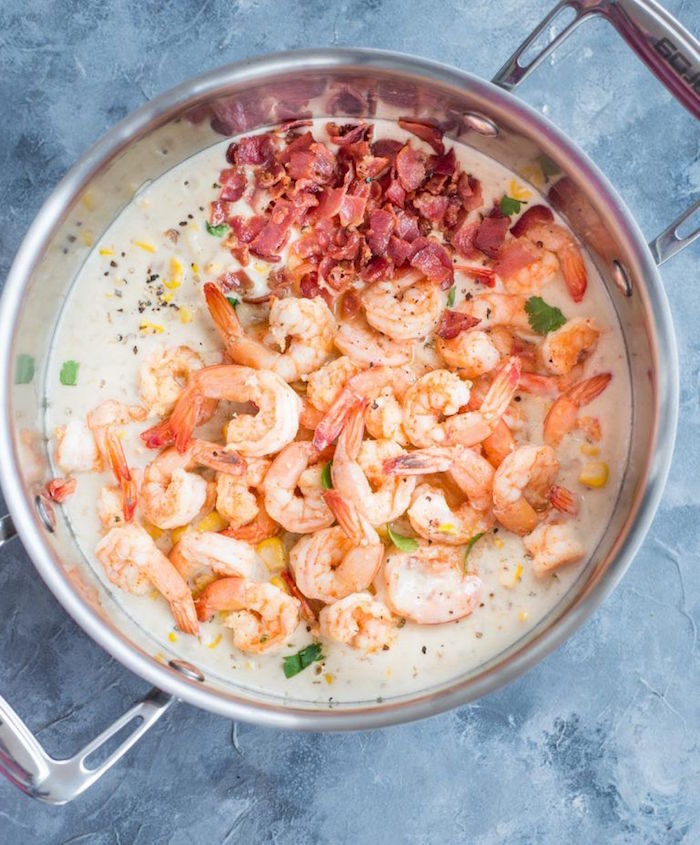 pot filled with creamy soup with corn shrimp bacon how to cook raw shrimp placed on granite surface