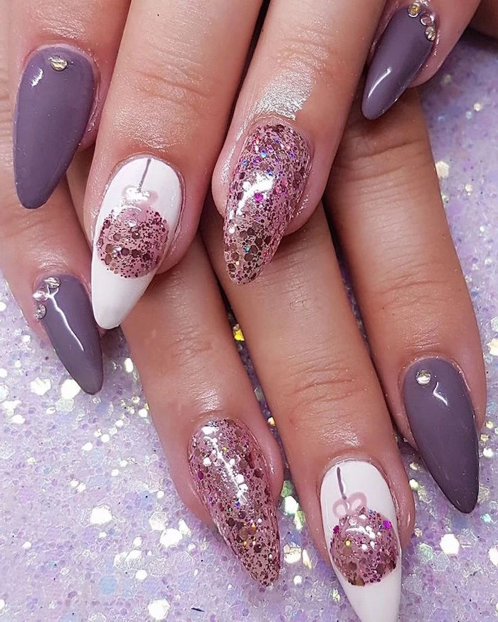 purple white and rose gold glitter nail polish on long stiletto nails holiday nail designs bauble decorations on middle fingers