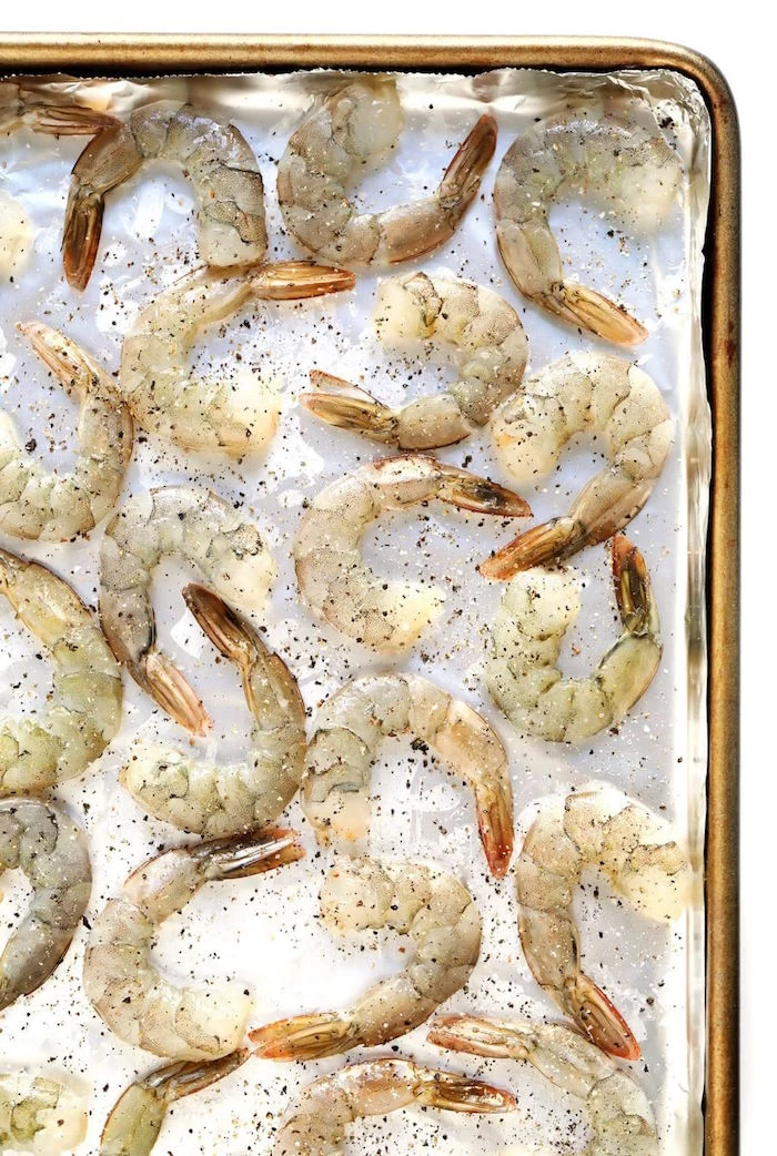 raw shrimp garnished with herbs arranged on paper lined baking sheet shrimp dinner ideas