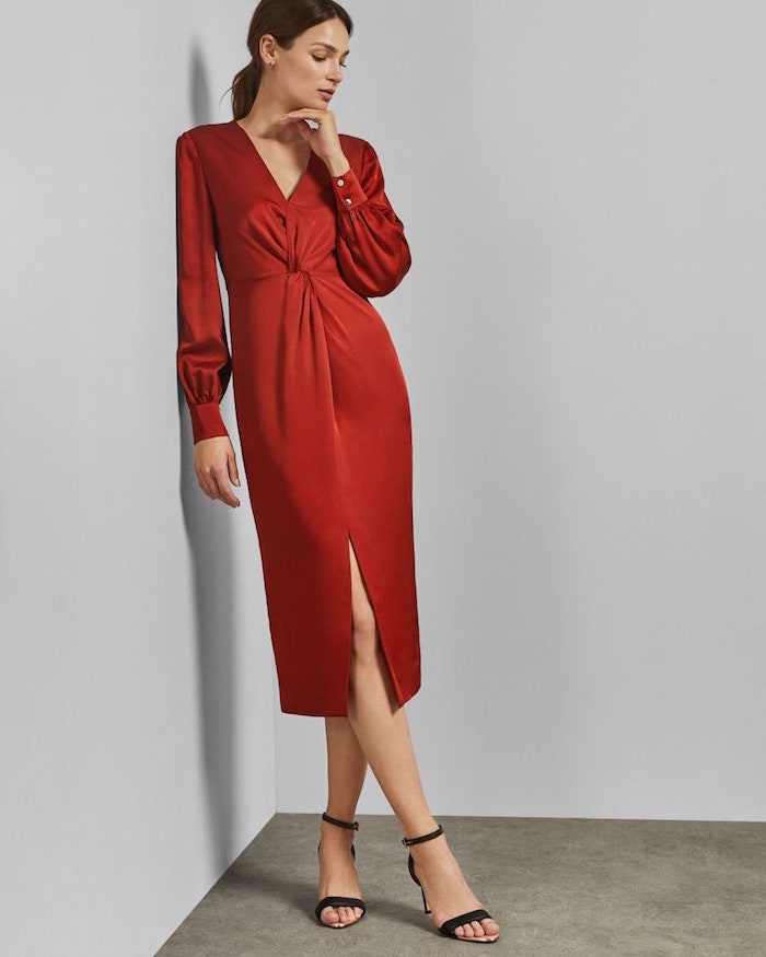 red satin dres with long sleeves worn by woman with brunette hair in low ponytail formal wedding guest dresses black sandals with heels