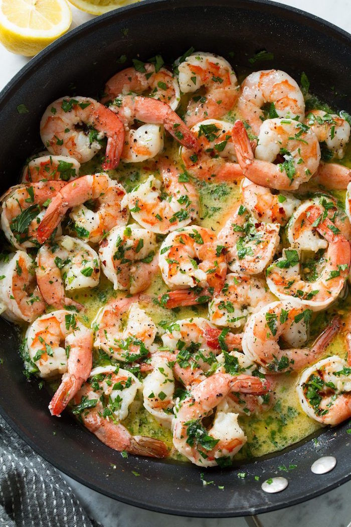 shrimp scampi in creamy sauce garnished with chopped parsley cooked in black skillet cooked shrimp recipes