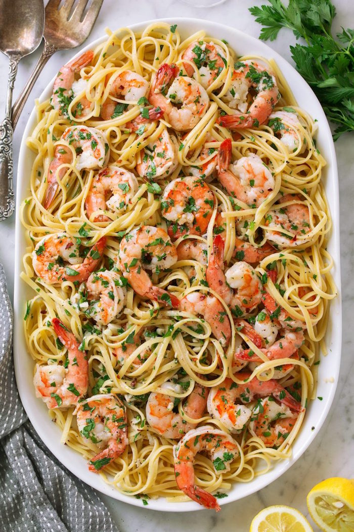 shrimp scampi with noodles garnished with chopped parsley cooked shrimp recipes placed in large white plate