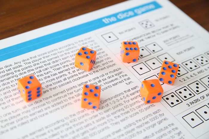six orange dice with blue dots fun things to do with kids paper with the rules of the dice game written on it