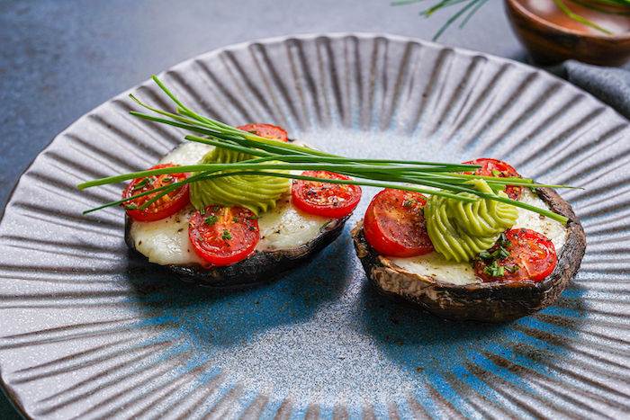 thanksgiving side dish recipes stuffed portobello mushrooms with baby mozzarella cherry tomatoes placed on black plate