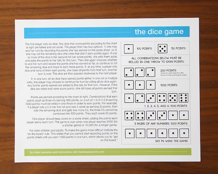 the dice game instructions written on large piece of paper fun things to do with kids placed on wooden surface