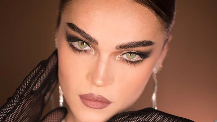 thick eyebrows on green eyed woman with brown hair winged eyeliner for hooded eyes nude lipstick