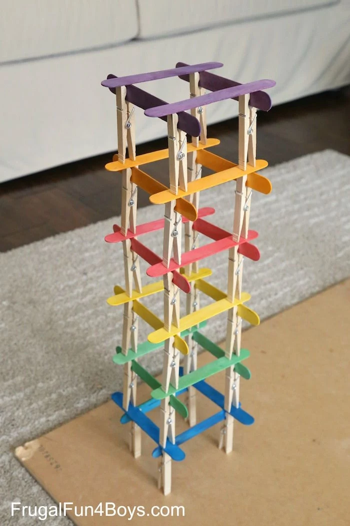 tower built out of popsicle sticks in purple orange red yellow green blue clothespins fun things to do with kids