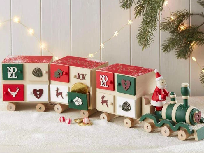 toy train with three wooden carriages with small boxes with candy inside fun advent calendars decorated in green and red