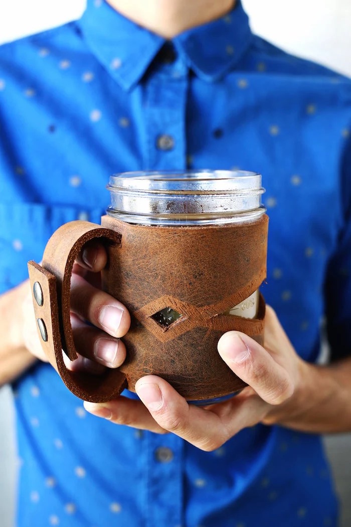 unique gifts for dad man wearing blue shirt holding a mug with leather jar sleeve around it made from brown leather