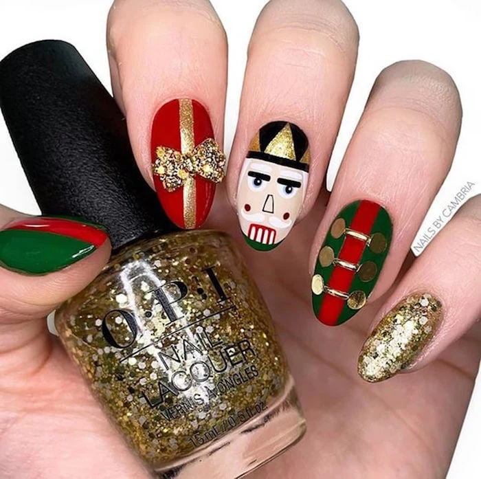 white background christmas nail designs 2020 nutcracker inspired nail design with gold glitter red green black white nail polish
