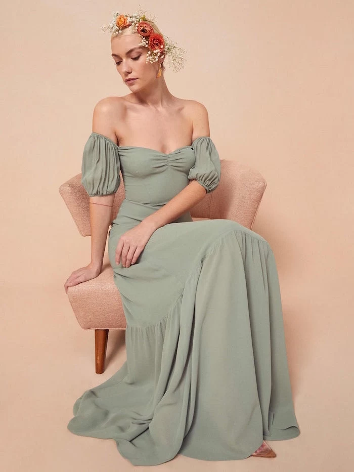 woman sitting on pink chair semi formal dresses for wedding wearing long green off the shoulder dress