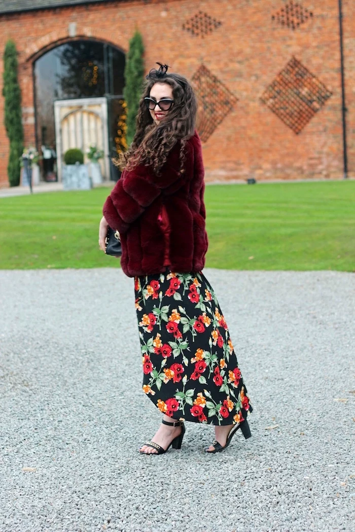 womens wedding guest dresses woman with long black curly hair long floral dress red furry coat black sandals
