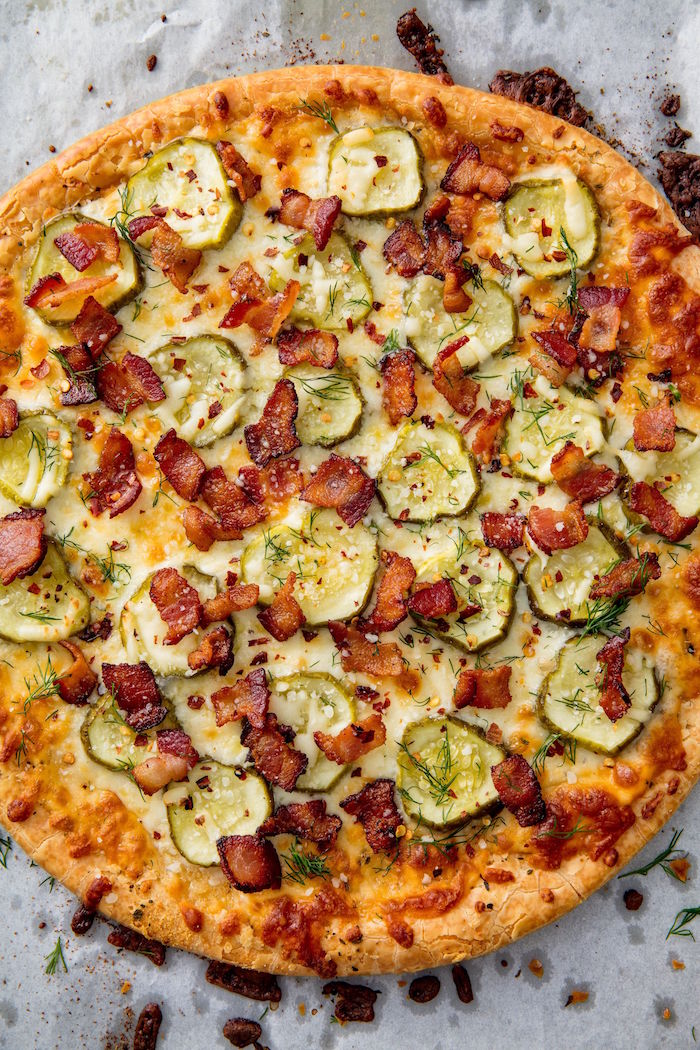 baked pizza with pickles bacon garnished with fresh dill how to make pizza dough placed on paper lined surface