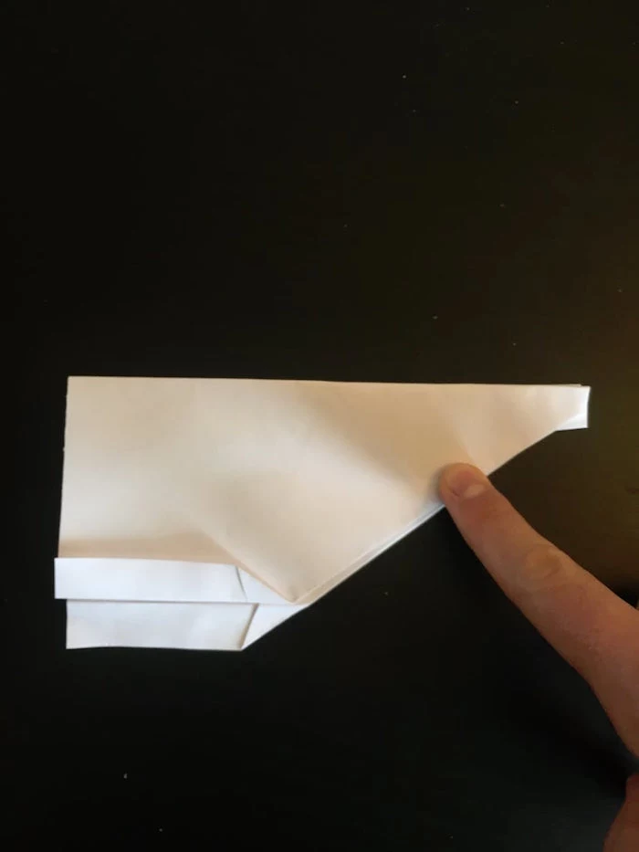 best paper airplane design black background a white piece of paper folded into a plane