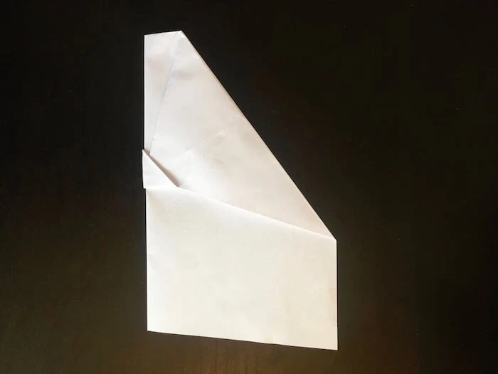 black background step by step diy tutorial paper airplane folding white piece of paper turned into a plane