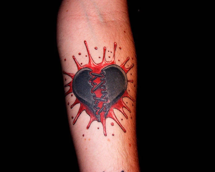 black heart cracked in the middle heart tattoo on hand splash of red blood as background forearm tattoo