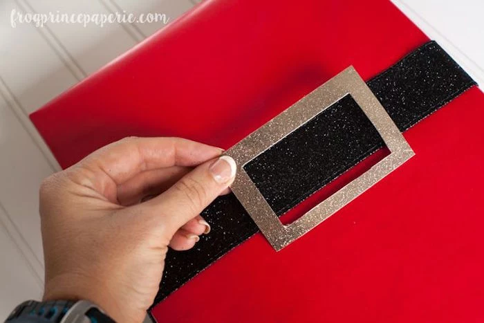 box wrapped with red wrapping paper gift packing ideas black glitter ribbon with gold glitter belt buckle to represent santa