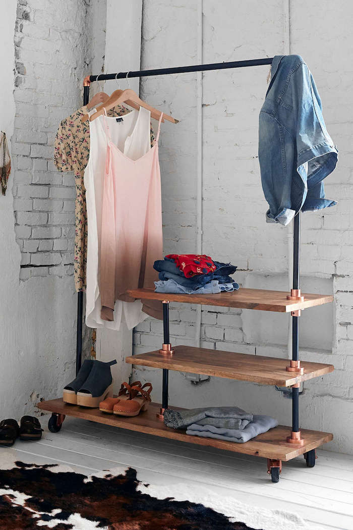 clothing rail made with industrial pipes white wooden floor white brick wall faux animal skin rug