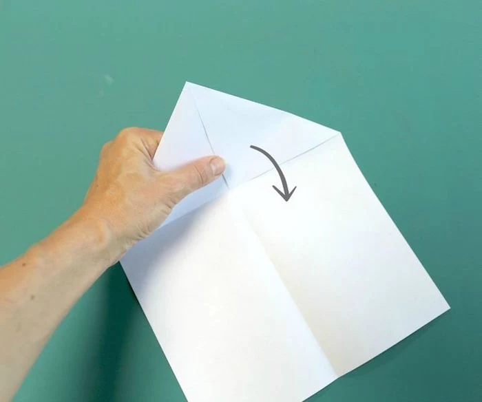 folding a white piece of paper to turn into a plane how to make a paper airplane easy diy tutorial