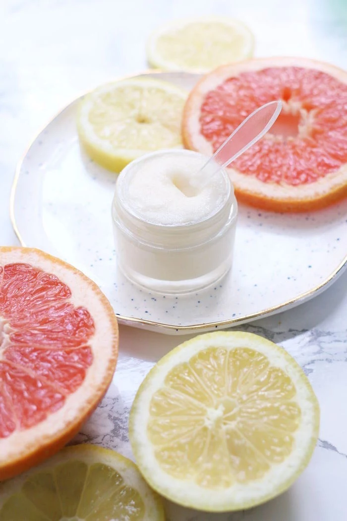 grapefruit and lemon sliced on marble surface with ceramic plate how to use lip scrub plastic container with lip scrub