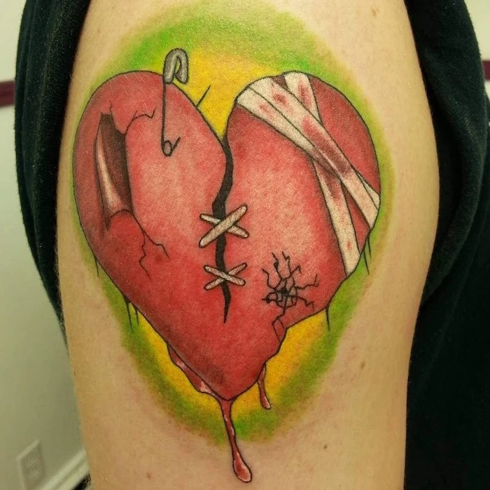 green background on red heart broken with stitches safety pin bandages heart tattoo on chest shoulder tattoo