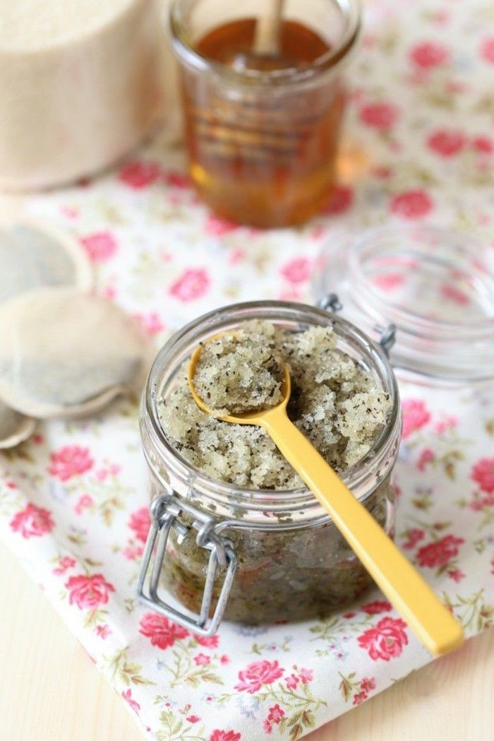 green tea lip scrub poured into small jar with lid plastic spoon inside how to use lip scrub placed on floral tray