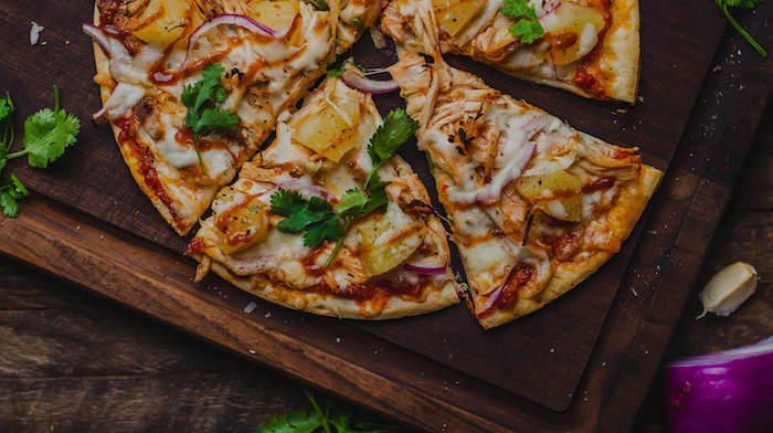 hawaiian style pizza best pizza dough recipe veggie pizza with pineapple cut into slices placed on wooden board