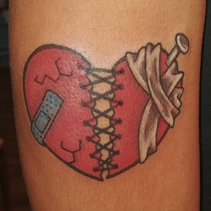 heart tattoos for men red heart broken in the middle held together with thread with bandages nail in it