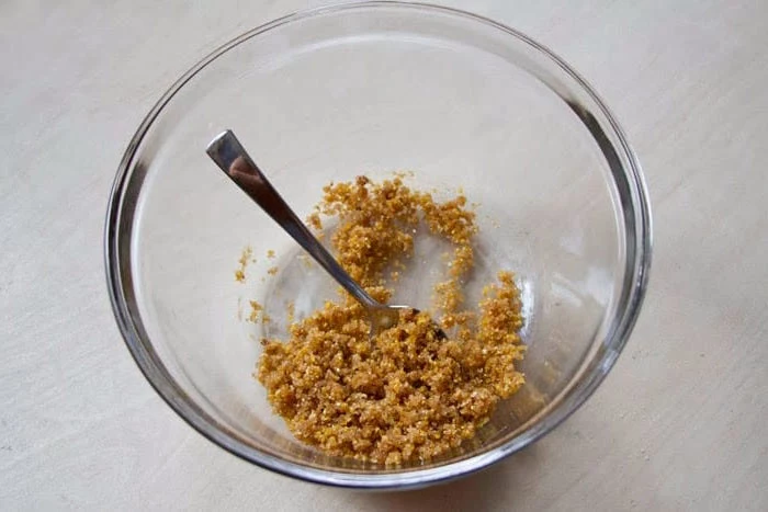 how to use lip scrub ingredients for lip scrub recipe being mixed together with small spoon in glass bowl