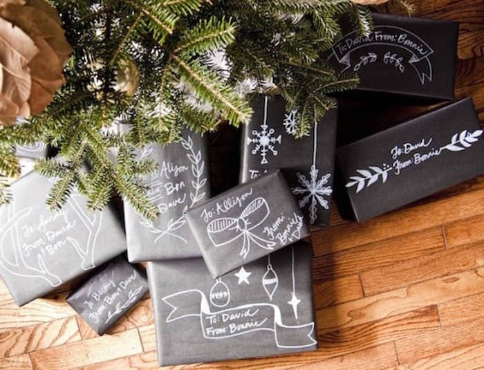 lots of gifts under the tree on wooden floor gift wrapping ideas wrapepd with black paper drawn with white markers