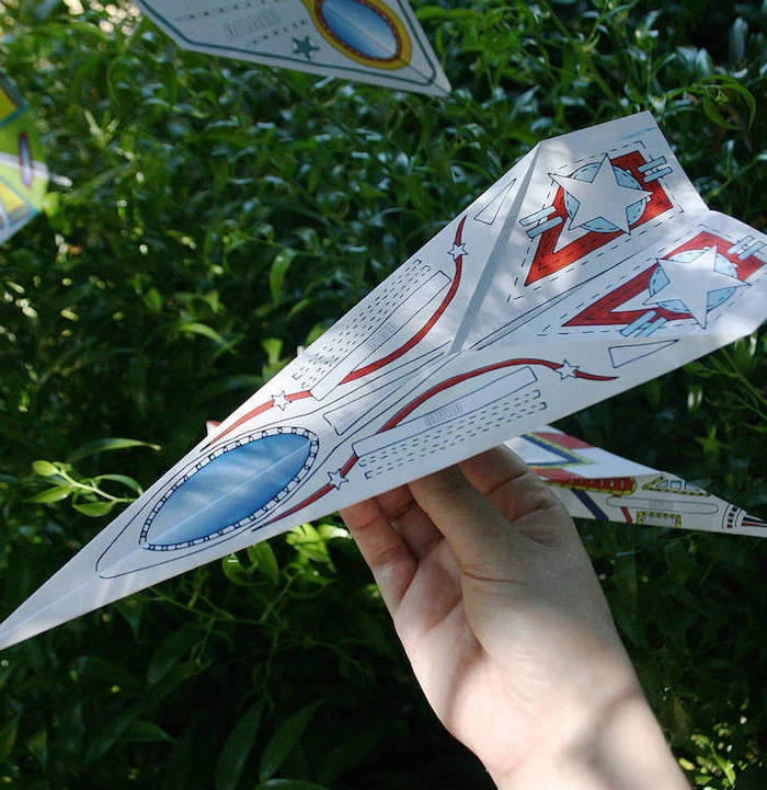 paper airplane instructions made with printable paper with drawings in blue and red on it