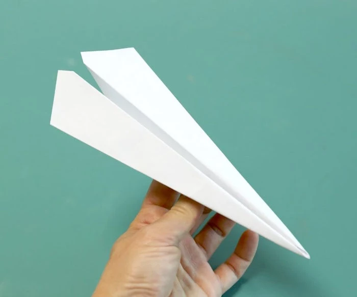 paper plane made out of white piece of paper how to make a paper airplane easy photographed on turquoise background