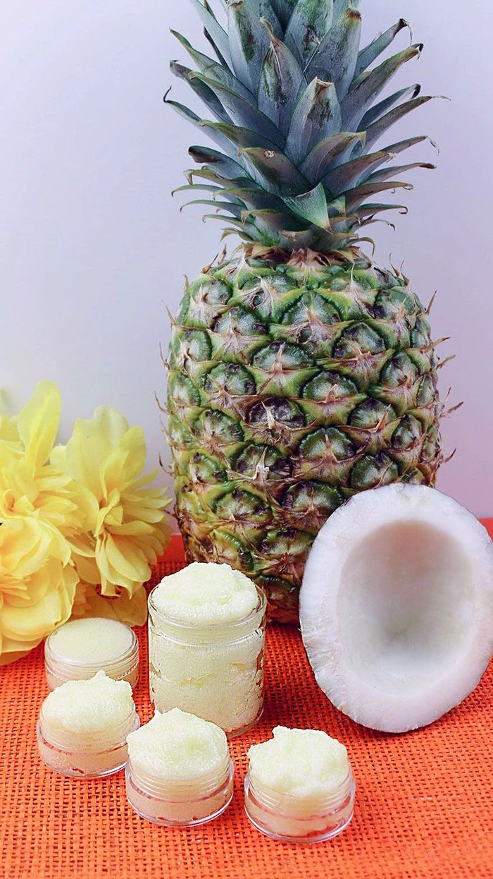 pineapple coconut placed on table with orange table cloth how to exfoliate lips plastic containers filled with lip scrub