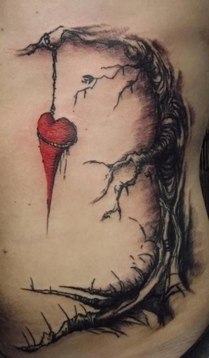 red heart hanging from a tree heart tattoos for men tattoo on the side of the stomach