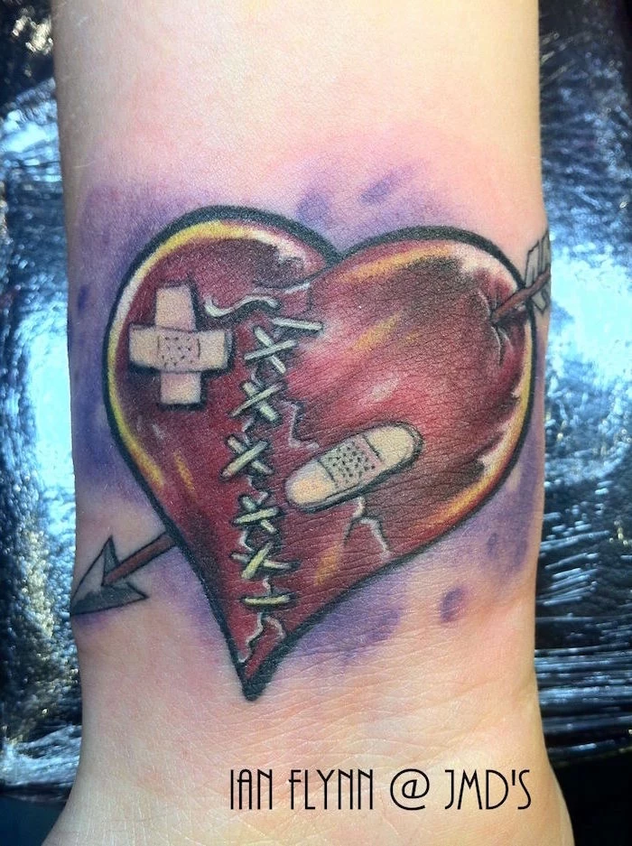red heart with arrow going through it bandages broken heart tattoo stitched in the middle purple watercolor background