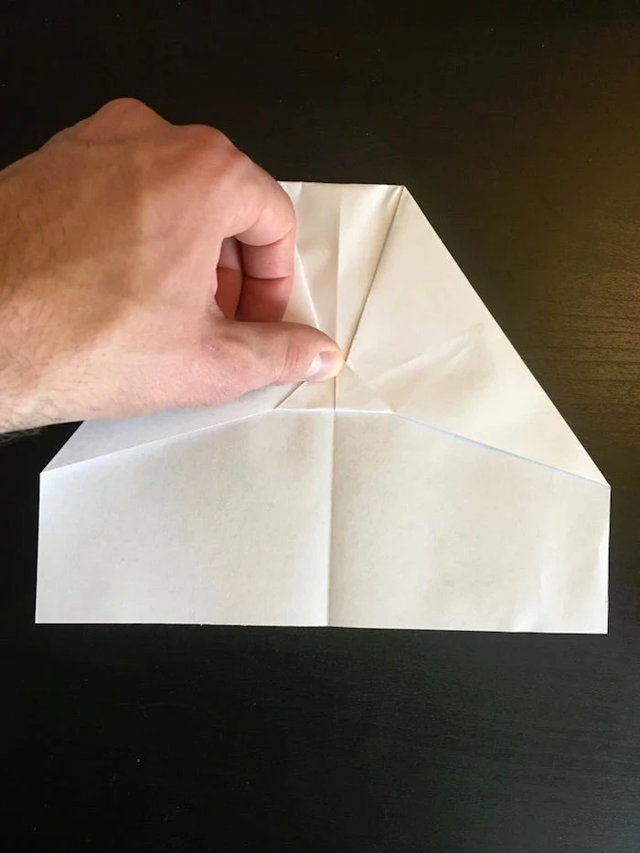 step by step diy tutorial best paper airplane design white piece of paper being folded into a plane