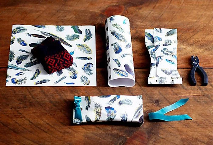 step by step diy tutorial how to wrap oddly shaped gifts best way to wrap presents white paper with feathers drawn on it