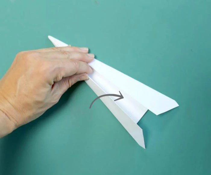 step by step diy tutorial on folding a paper airplane paper airplane instructions turquoise background