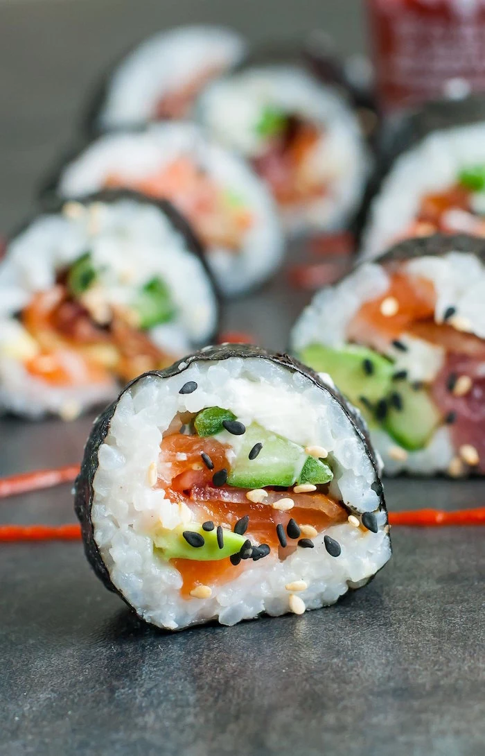 sushi with bacon avocado salmon black sesame seeds how to make sushi rice placed on black surface