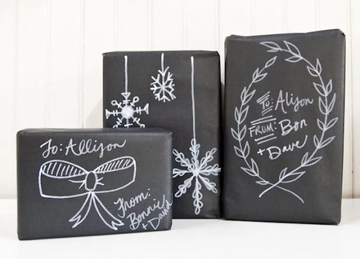 three boxes wrapped in black wrapping paper gift wrapping ideas different things written and drawn on it with white marker