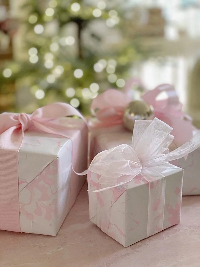 three boxes wrapped with pink and white marble paper how to wrap a present pink silk and tulle bows wrapped around them