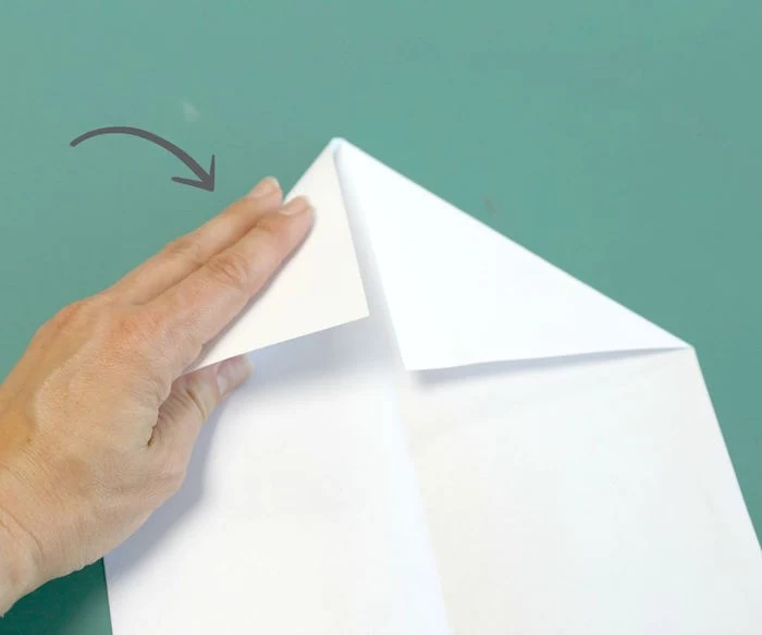 turquoise background how to make a paper airplane easy a piece of white paper folded into a plane
