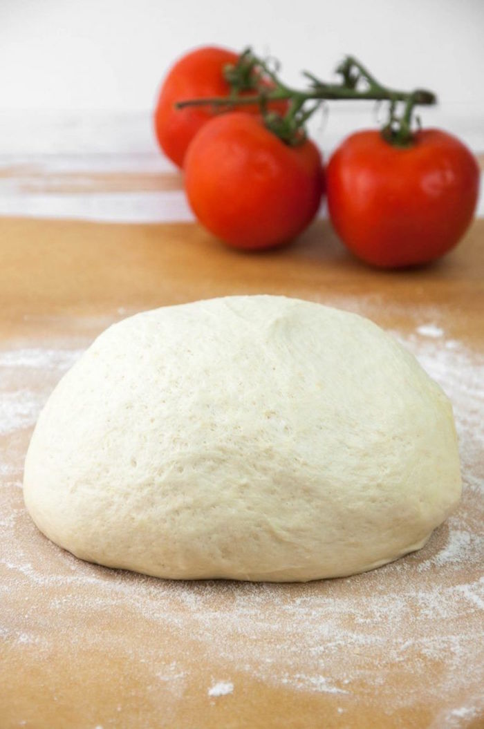 vegan pizza dough shaped into a ball placed on lightly floured wooden surface how to make pizza from scratch