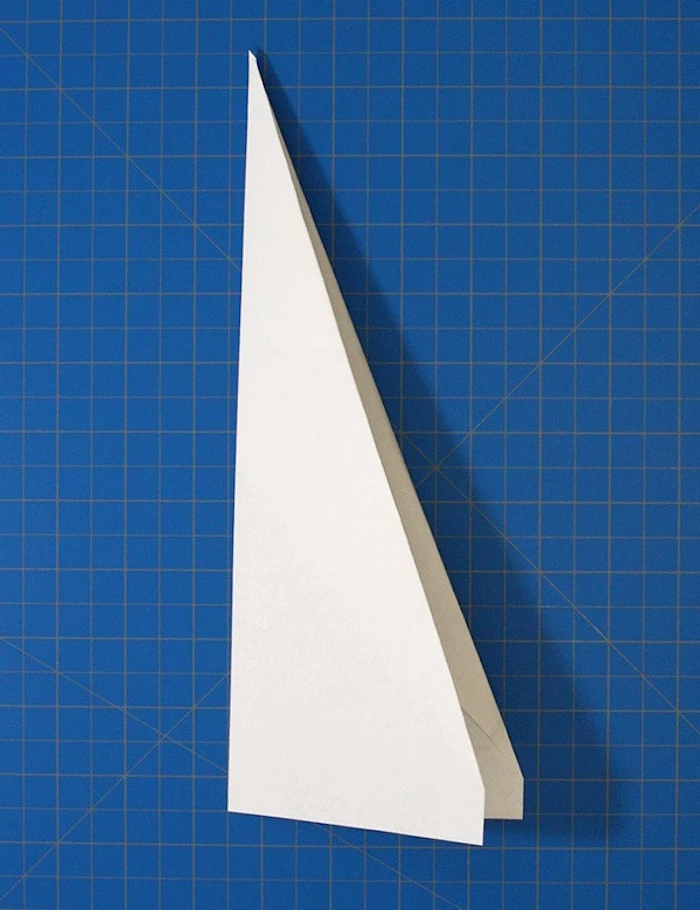 white piece of paper folded into plane how to make a paper airplane that flies far blue background