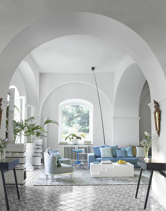 beach house decor open plan living room with cathedral ceiling blue sofa gram armchairs lots of blue throw pillows tiled floor