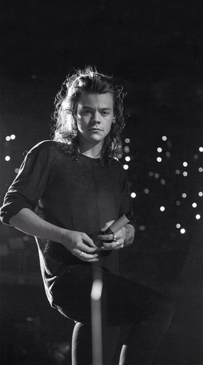 black and white photo of harry with long curly hair harry styles iphone wallpaper standing on stage