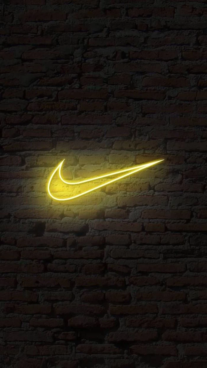 black background with brick wall just do it wallpaper yellow nike neon logo in the middle