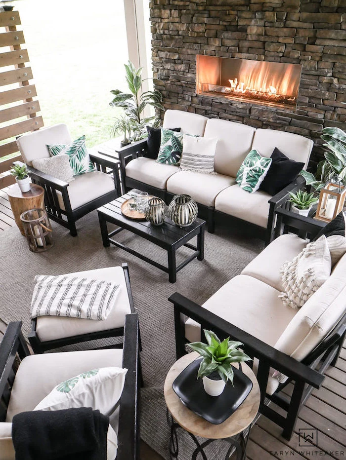 black wooden sofas and armchairs with white cushions green and white throw pillows beach themed decor stone fireplace
